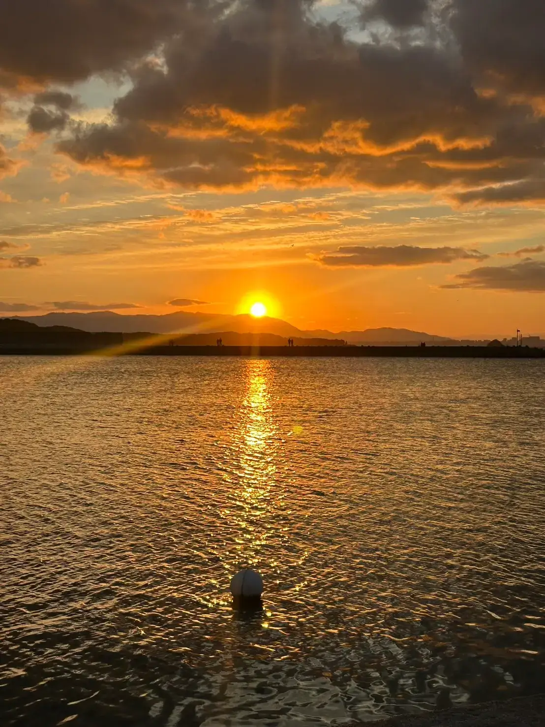 志賀島東海岸の山並みから顔を出す2026年の初日の出。夜明け直後のオレンジ色の空と静かな博多湾。